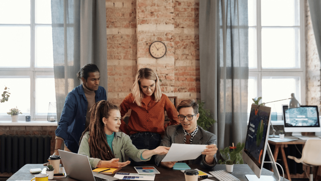 a group of people working together in an office with a cup of coffee