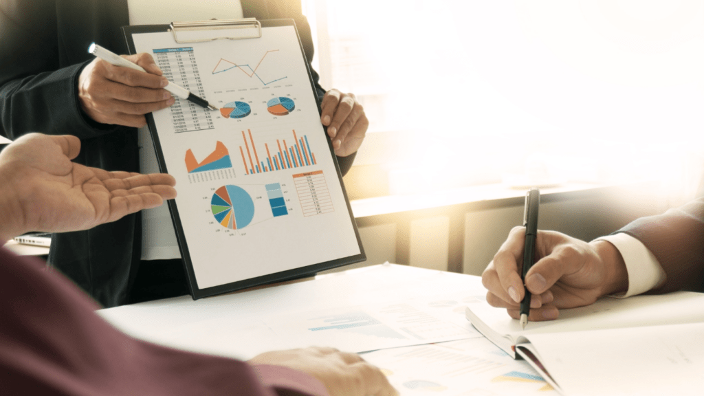 a group of business people sitting around a table with graphs and papers