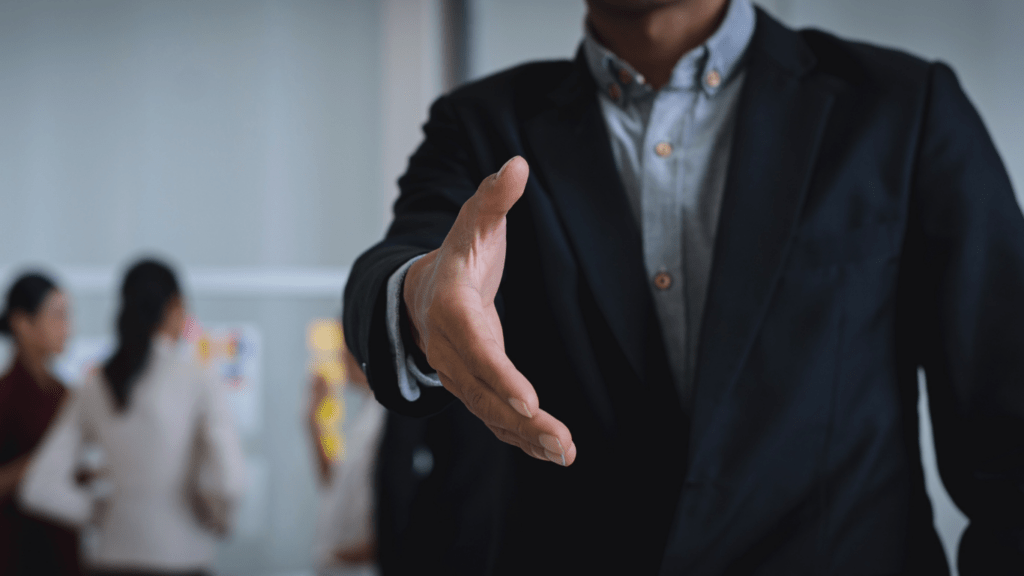 Businessman open hand offering handshake in office