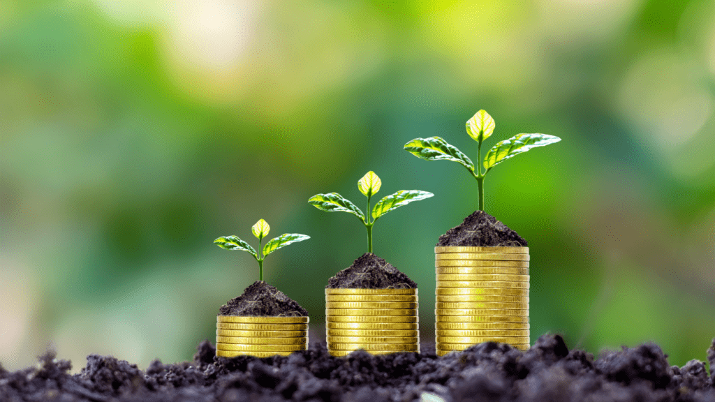 three gold coins with green sprouts growing on top of them