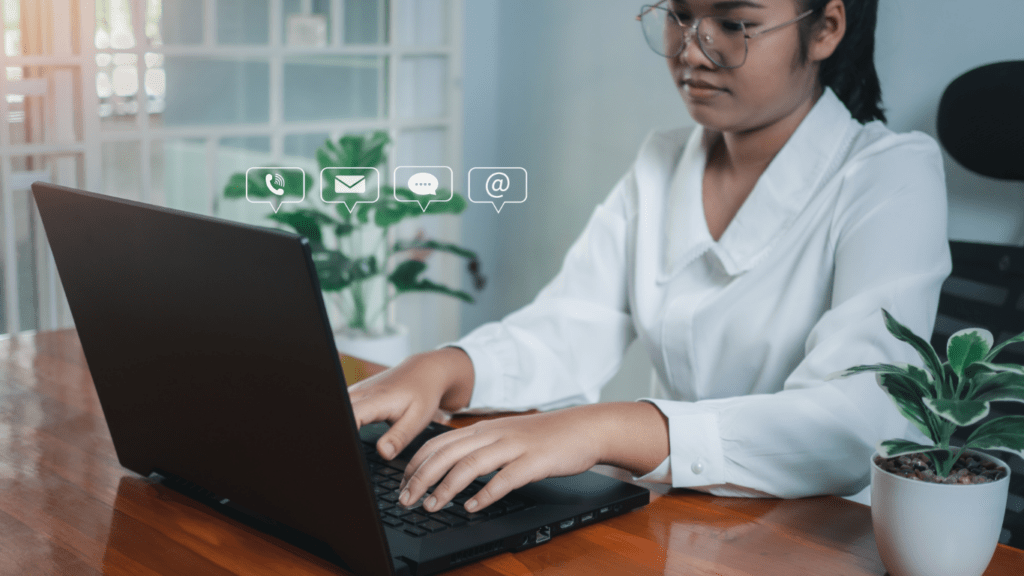 a person in a white shirt is typing on a laptop