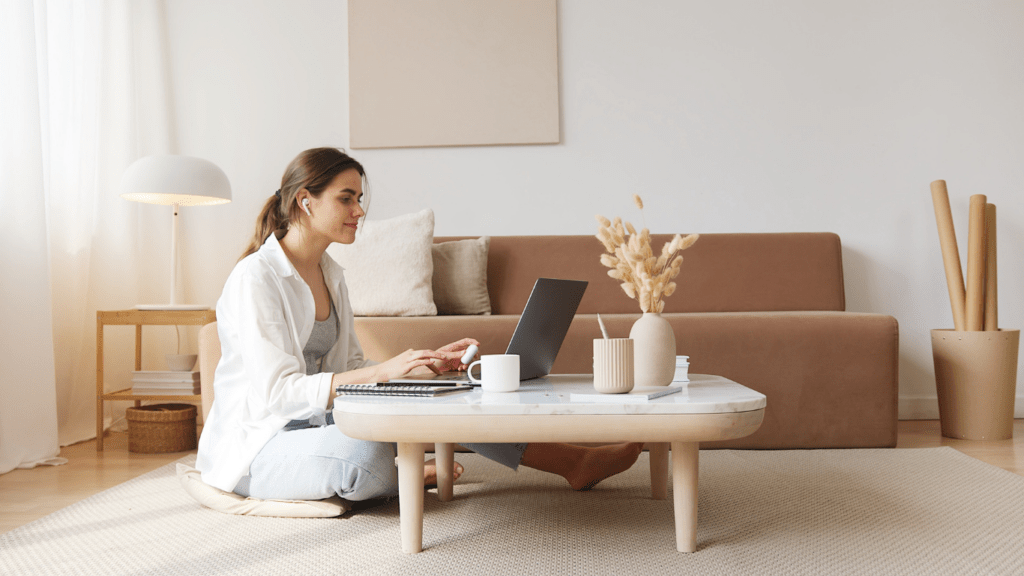 a person is sitting on the floor using a laptop