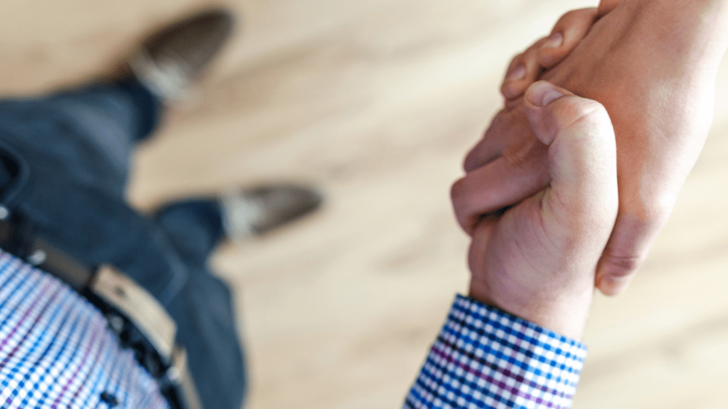 Two business people shaking hands in front of each other