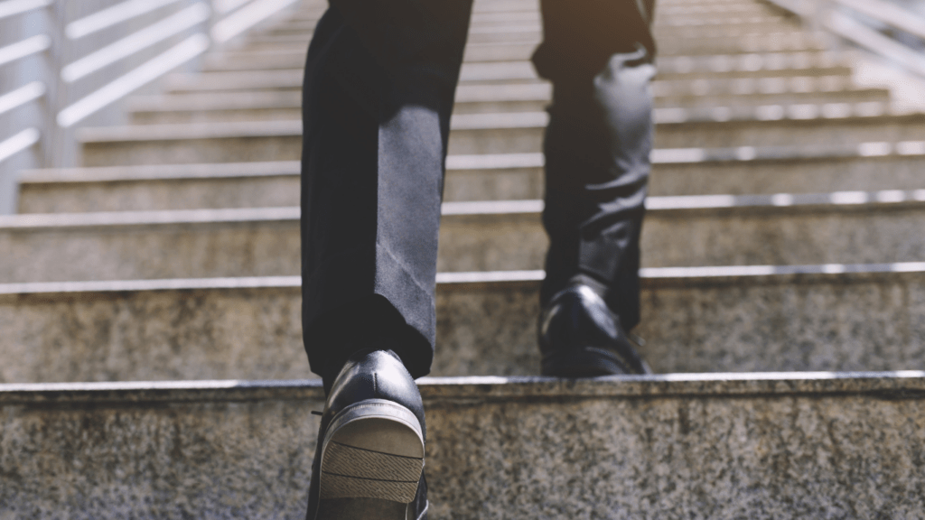 a person wearing black shoes standing on some stairs