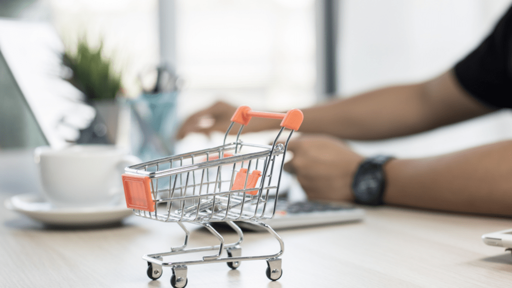 a person sitting at a desk with a shopping cart in front of them