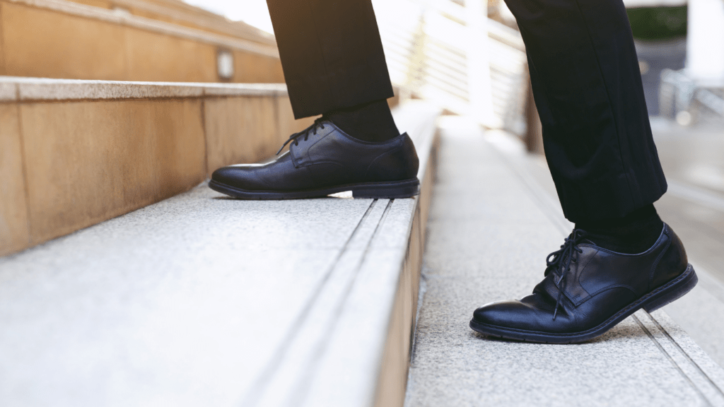 a person wearing black shoes standing on some stairs